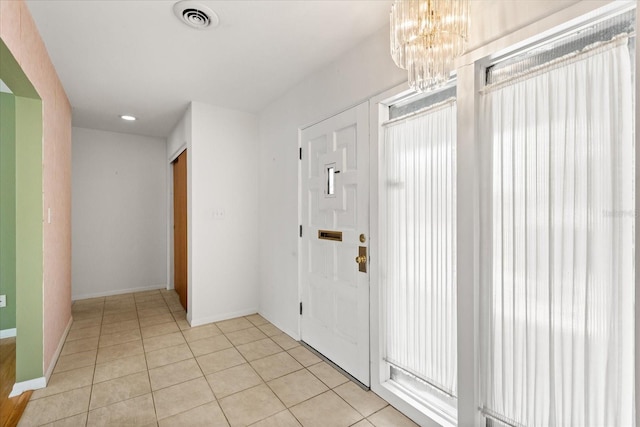 entrance foyer with light tile patterned flooring, a notable chandelier, visible vents, and baseboards