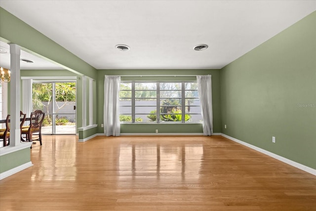 interior space featuring baseboards, light wood-type flooring, and visible vents