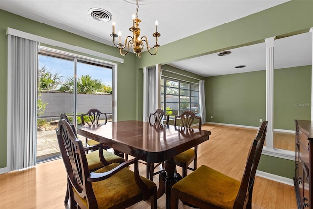 dining area featuring visible vents, light wood-style flooring, baseboards, and an inviting chandelier