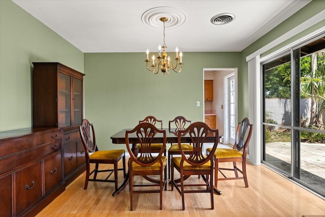 dining area with visible vents, light wood-style flooring, and a chandelier