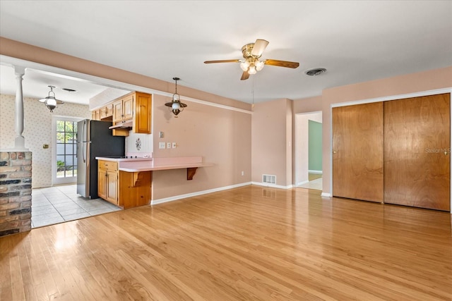 kitchen with visible vents, a ceiling fan, light wood finished floors, and light countertops