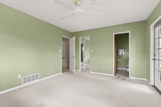 unfurnished bedroom featuring visible vents, connected bathroom, baseboards, and carpet floors