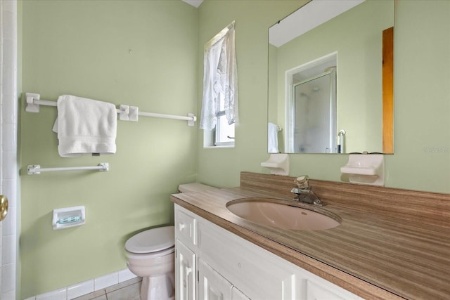 bathroom with an enclosed shower, vanity, tile patterned flooring, and toilet
