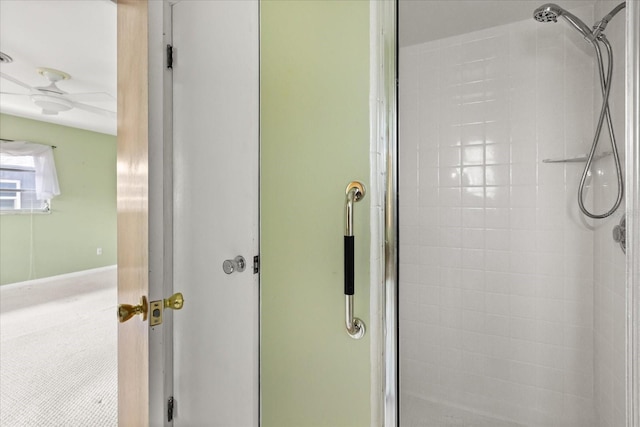 full bathroom featuring ceiling fan and a shower stall