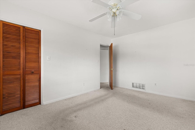 spare room with carpet flooring, a ceiling fan, baseboards, and visible vents