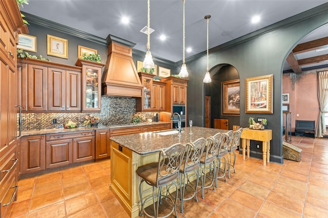 9730 Lounsberry Cir, Golden Oak, FL 32836 - kitchen with a sink, arched walkways, tasteful backsplash, custom exhaust hood, and dark stone counters