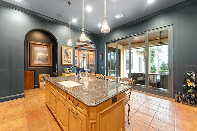 9730 Lounsberry Cir, Golden Oak, FL 32836 - kitchen with a sink, a center island with sink, a kitchen bar, dark stone countertops, and arched walkways