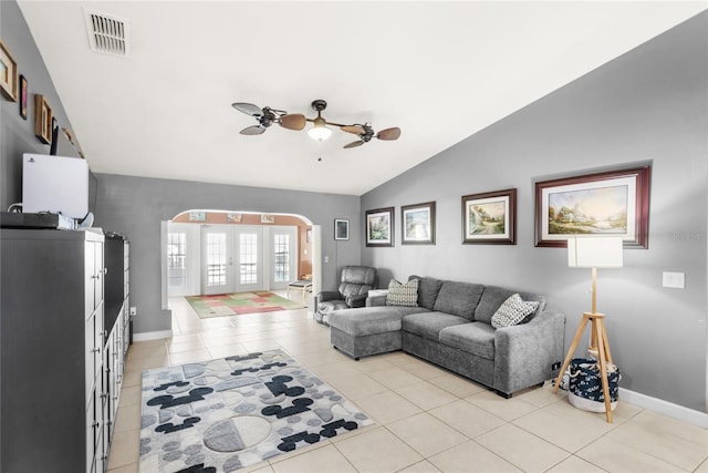 living room featuring light tile patterned flooring, arched walkways, french doors, a ceiling fan, and visible vents