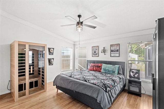 bedroom with crown molding, baseboards, vaulted ceiling, and light wood finished floors