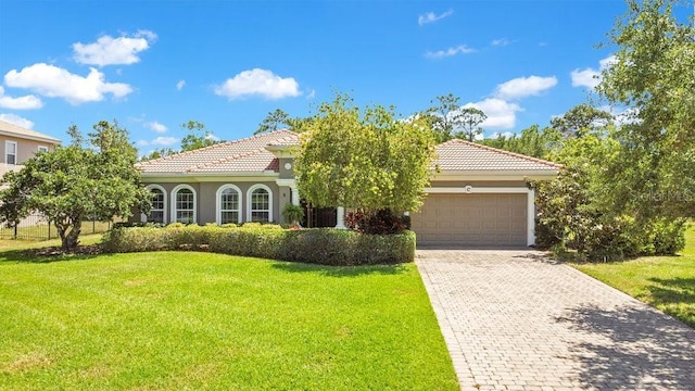 18108 Bellezza Dr, Orlando, FL 32820 - mediterranean / spanish-style home featuring a garage, stucco siding, decorative driveway, and a front lawn