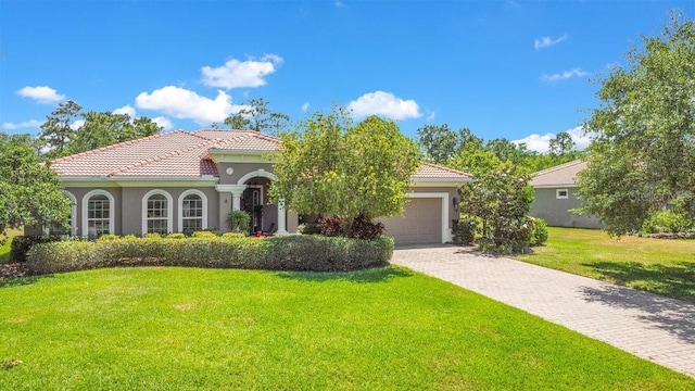18108 Bellezza Dr, Orlando, FL 32820 - mediterranean / spanish home with a garage, stucco siding, a front yard, decorative driveway, and a tiled roof