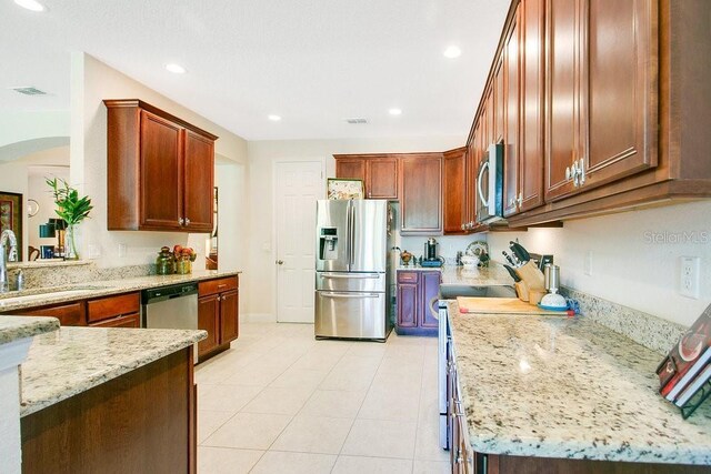 18108 Bellezza Dr, Orlando, FL 32820 - kitchen featuring a sink, light stone counters, stainless steel appliances, and visible vents