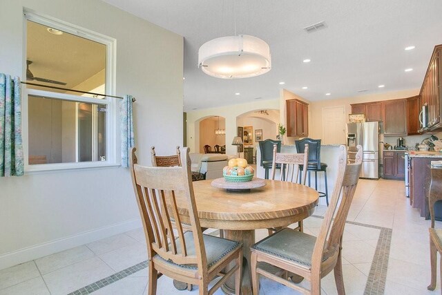 18108 Bellezza Dr, Orlando, FL 32820 - dining space featuring arched walkways, visible vents, light tile patterned floors, and recessed lighting