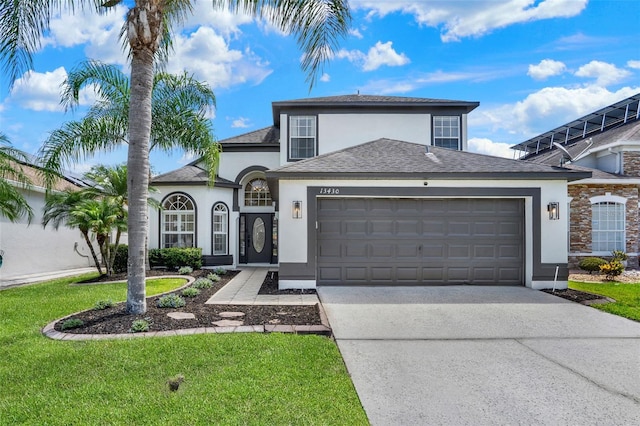view of front of house with a front yard, concrete driveway, an attached garage, a shingled roof, and stucco siding