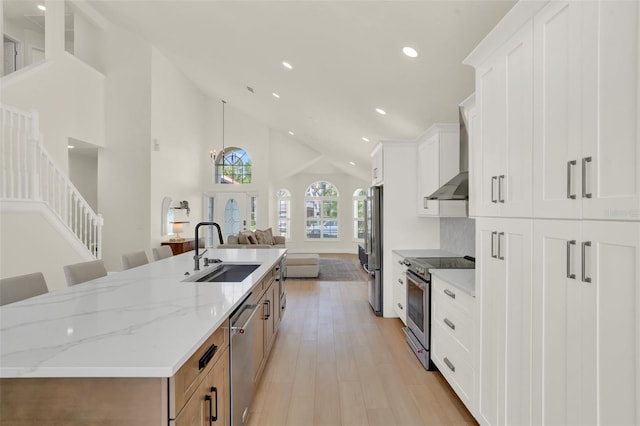 kitchen with a spacious island, high vaulted ceiling, recessed lighting, a sink, and appliances with stainless steel finishes