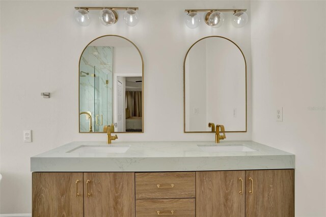 bathroom with double vanity, a sink, and a shower with shower door