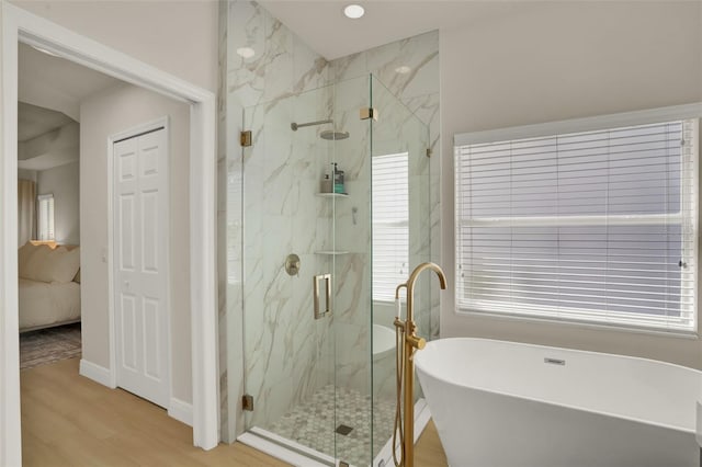full bath with a freestanding tub, ensuite bath, a marble finish shower, and wood finished floors