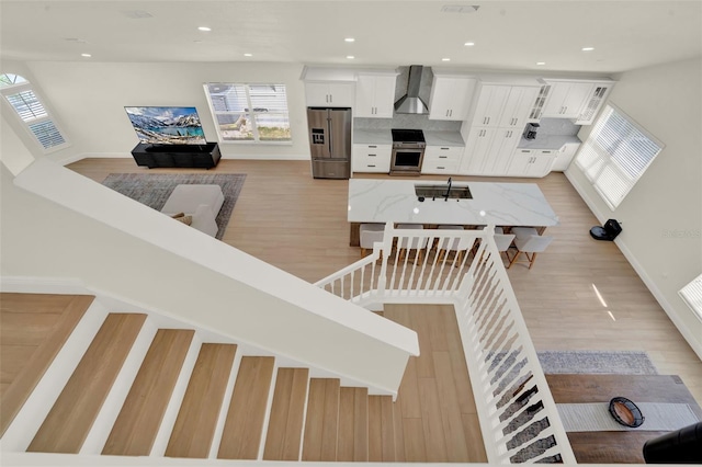 stairway with baseboards, recessed lighting, and wood finished floors