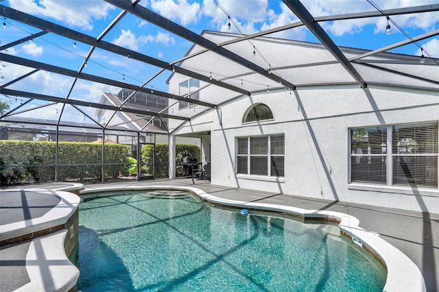 outdoor pool with a hot tub, a lanai, and a patio area