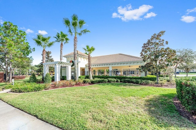 view of front of house with stucco siding, a pergola, a tile roof, and a front lawn