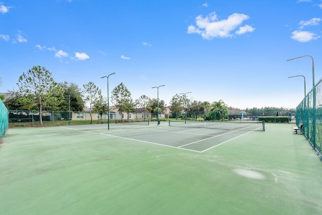 view of tennis court featuring fence