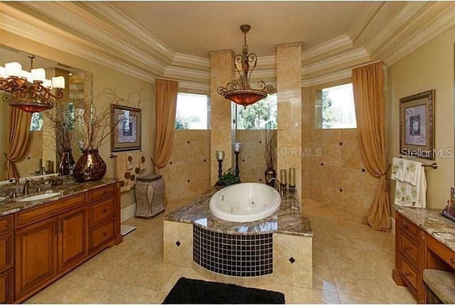 bathroom with a raised ceiling, ornamental molding, a tub with jets, and a notable chandelier