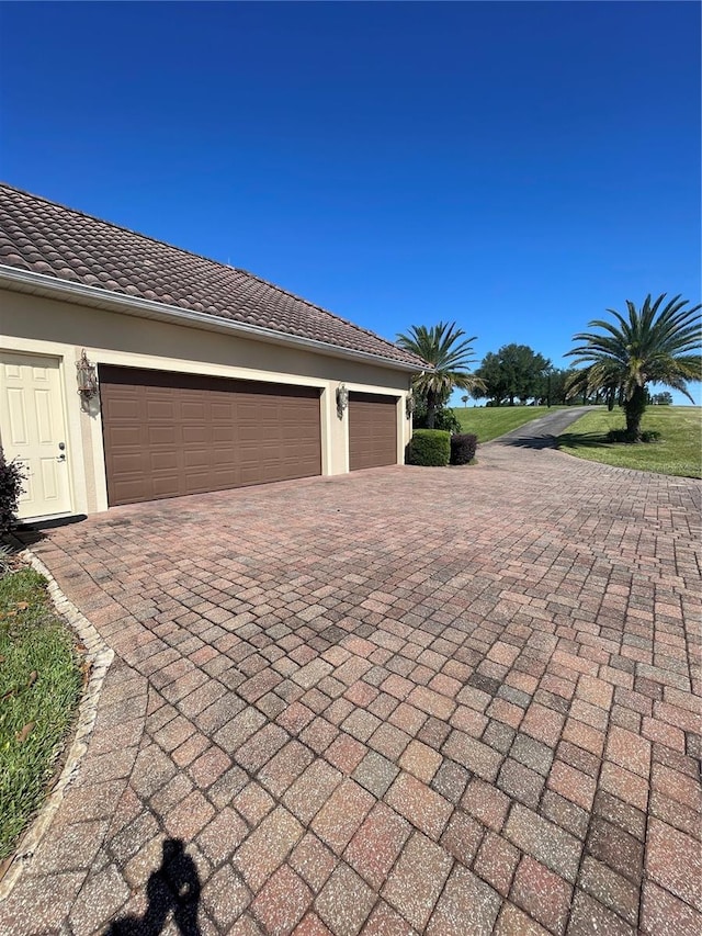 garage with decorative driveway
