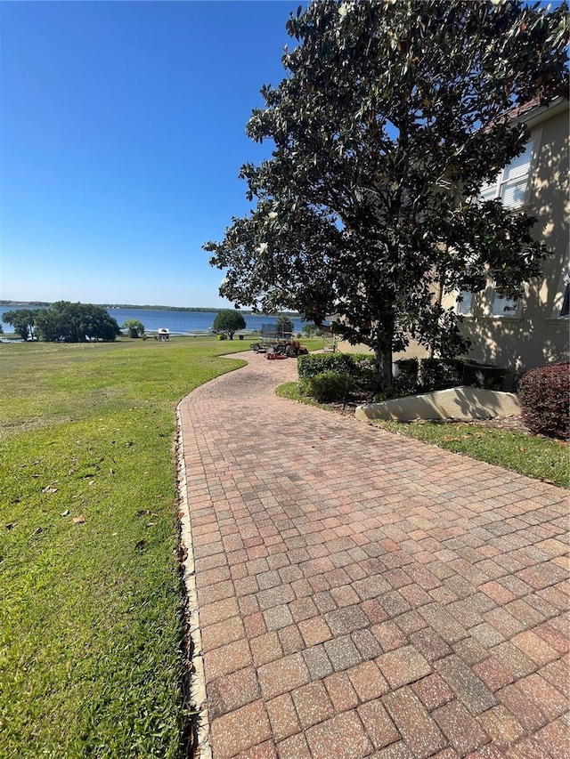 view of community with a water view and a yard