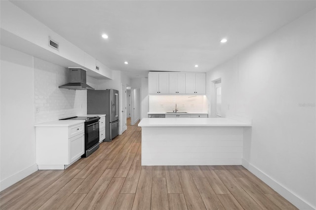 kitchen featuring freestanding refrigerator, visible vents, a sink, black electric range, and wall chimney range hood