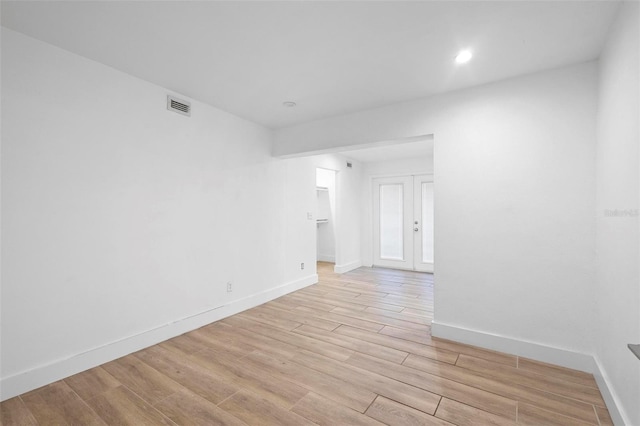 empty room with french doors, visible vents, recessed lighting, baseboards, and light wood-style floors