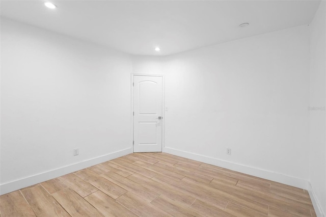 empty room featuring light wood-style flooring, baseboards, and recessed lighting