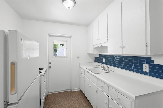 kitchen featuring white appliances, a sink, decorative backsplash, light countertops, and white cabinets