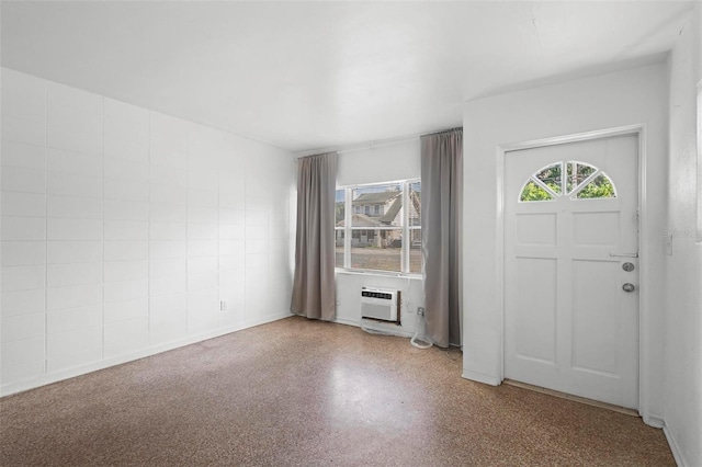 entrance foyer with a wall mounted air conditioner and speckled floor