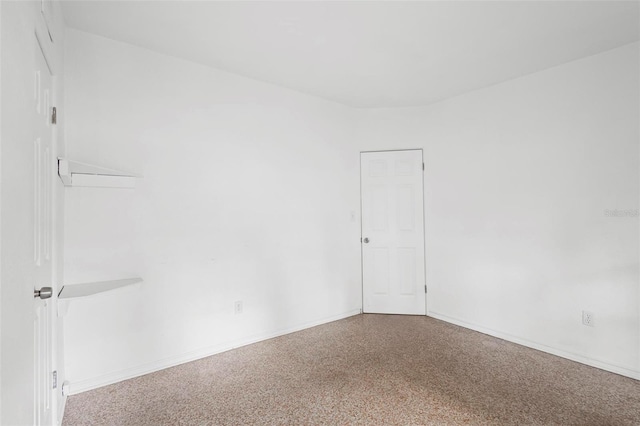 empty room with speckled floor and baseboards