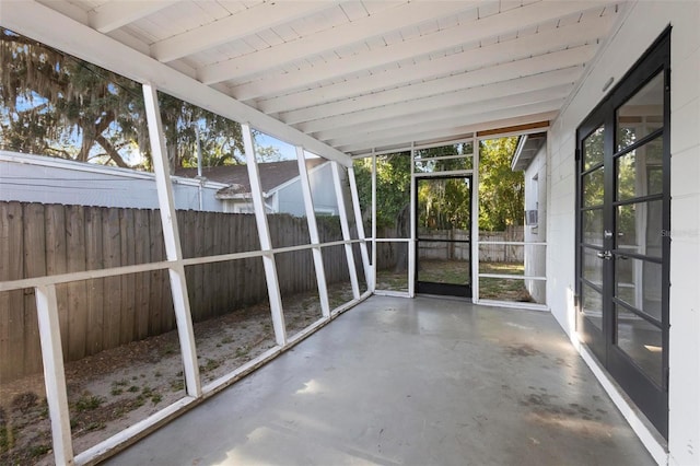 unfurnished sunroom featuring beamed ceiling