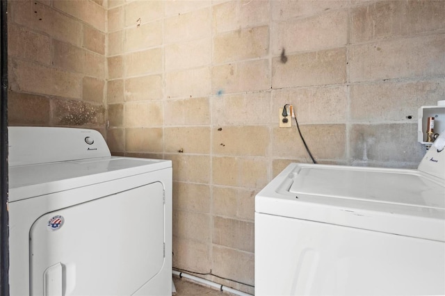 laundry area featuring laundry area, concrete block wall, and washer and dryer