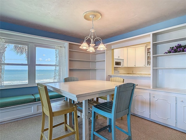 dining room with an inviting chandelier and light colored carpet