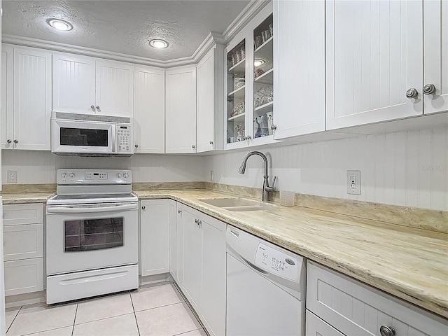 kitchen featuring light tile patterned flooring, white appliances, glass insert cabinets, white cabinets, and a sink