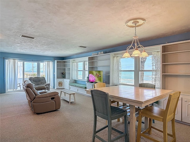carpeted dining space featuring visible vents
