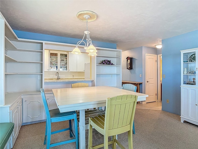 dining space featuring light carpet