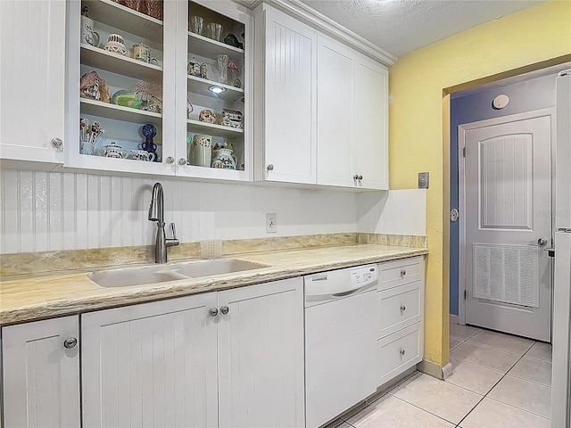kitchen with white dishwasher, a sink, white cabinets, and light countertops