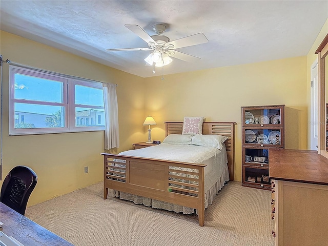bedroom with ceiling fan and light carpet