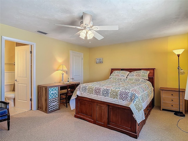 bedroom with light colored carpet, a ceiling fan, and visible vents
