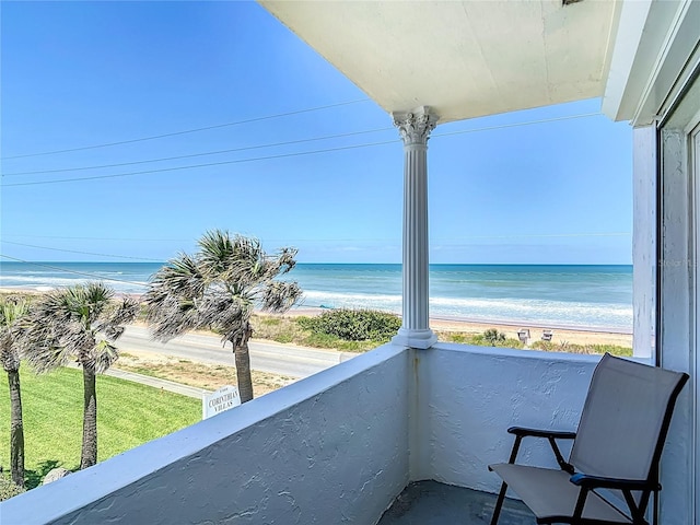 balcony featuring a beach view and a water view