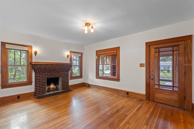 806 E Amelia St, Orlando, FL 32803 - unfurnished living room with a brick fireplace, wood-type flooring, and baseboards