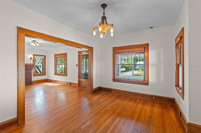 806 E Amelia St, Orlando, FL 32803 - empty room with baseboards, hardwood / wood-style floors, and a notable chandelier