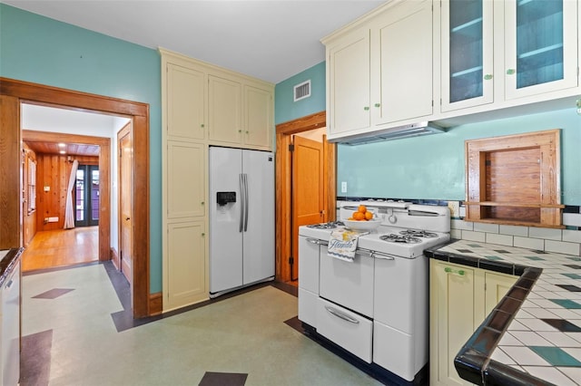 806 E Amelia St, Orlando, FL 32803 - kitchen with under cabinet range hood, white appliances, visible vents, cream cabinetry, and tile counters