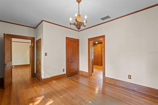 806 E Amelia St, Orlando, FL 32803 - spare room with a notable chandelier, baseboards, visible vents, crown molding, and light wood-type flooring