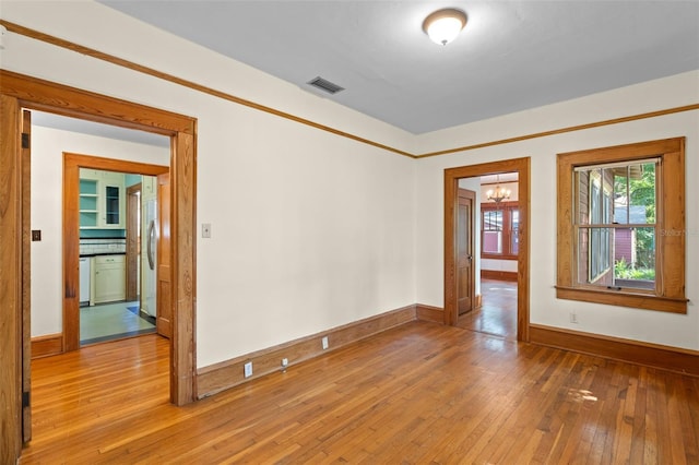 806 E Amelia St, Orlando, FL 32803 - unfurnished room featuring baseboards, light wood-style floors, a chandelier, and visible vents