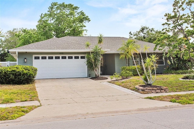 ranch-style house featuring a garage, a front lawn, stucco siding, a shingled roof, and concrete driveway